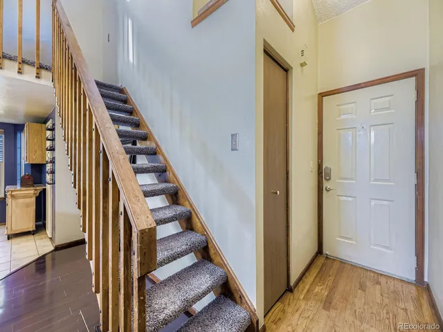 a view of a hallway with wooden floor and entryway