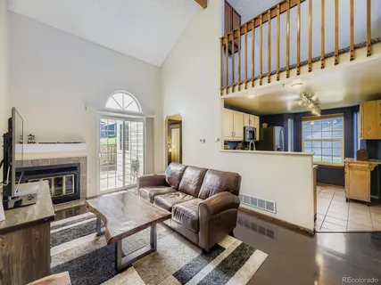 a living room with furniture a fireplace and a large window