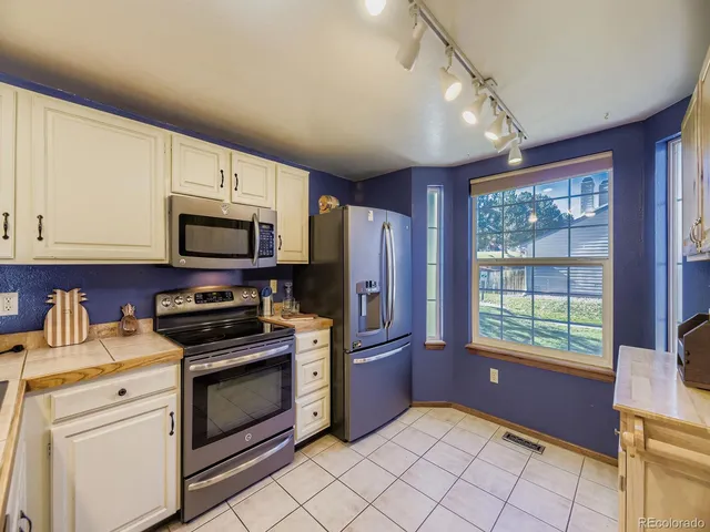 a kitchen with stainless steel appliances a stove sink microwave refrigerator and cabinets