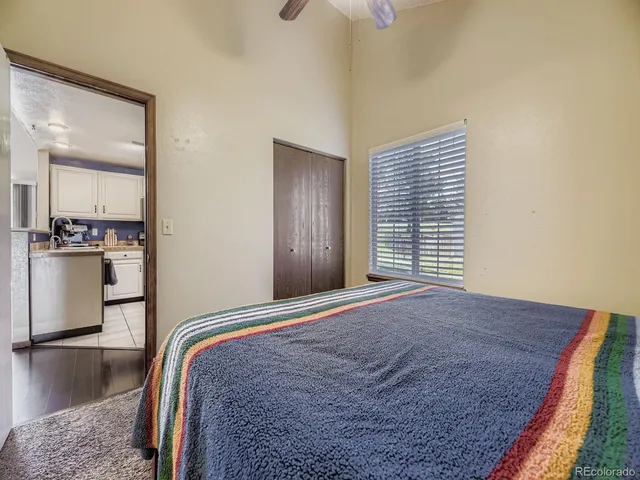 a bedroom with a bed and dresser with wooden floor