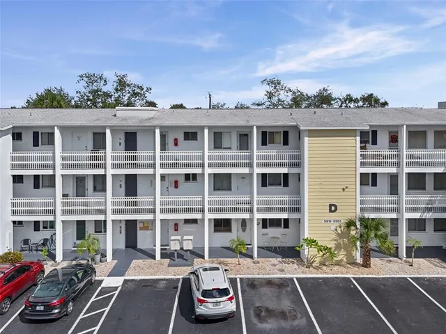 a front view of a building with cars parked