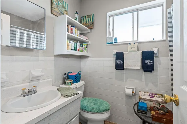a bathroom with a sink toilet and a mirror