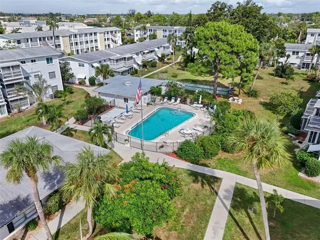 an aerial view of residential houses with outdoor space and trees