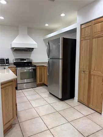 a kitchen with stainless steel appliances granite countertop a refrigerator a stove and a sink