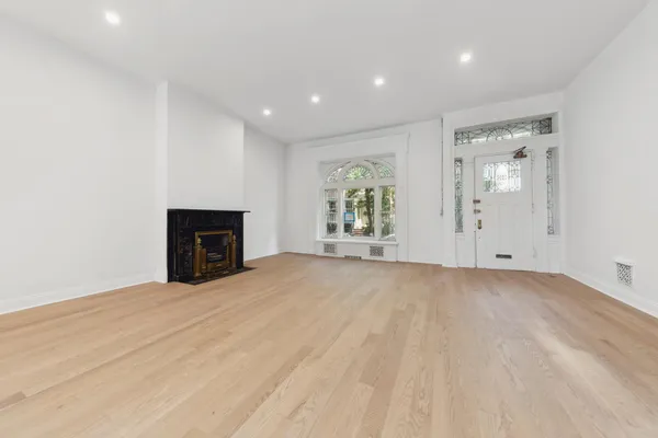 an empty room with windows and fireplace