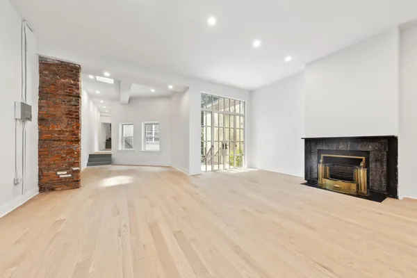 a view of an empty room with a fireplace and a window
