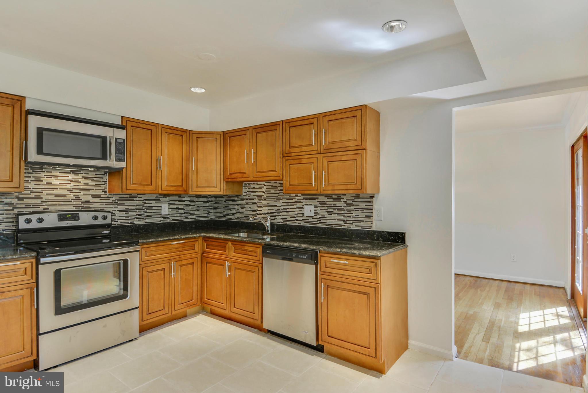 1409 Jackson Road Silver Spring, MD 20904 - Photo 11 of 30 a kitchen with stainless steel appliances granite countertop a stove a sink and a microwave