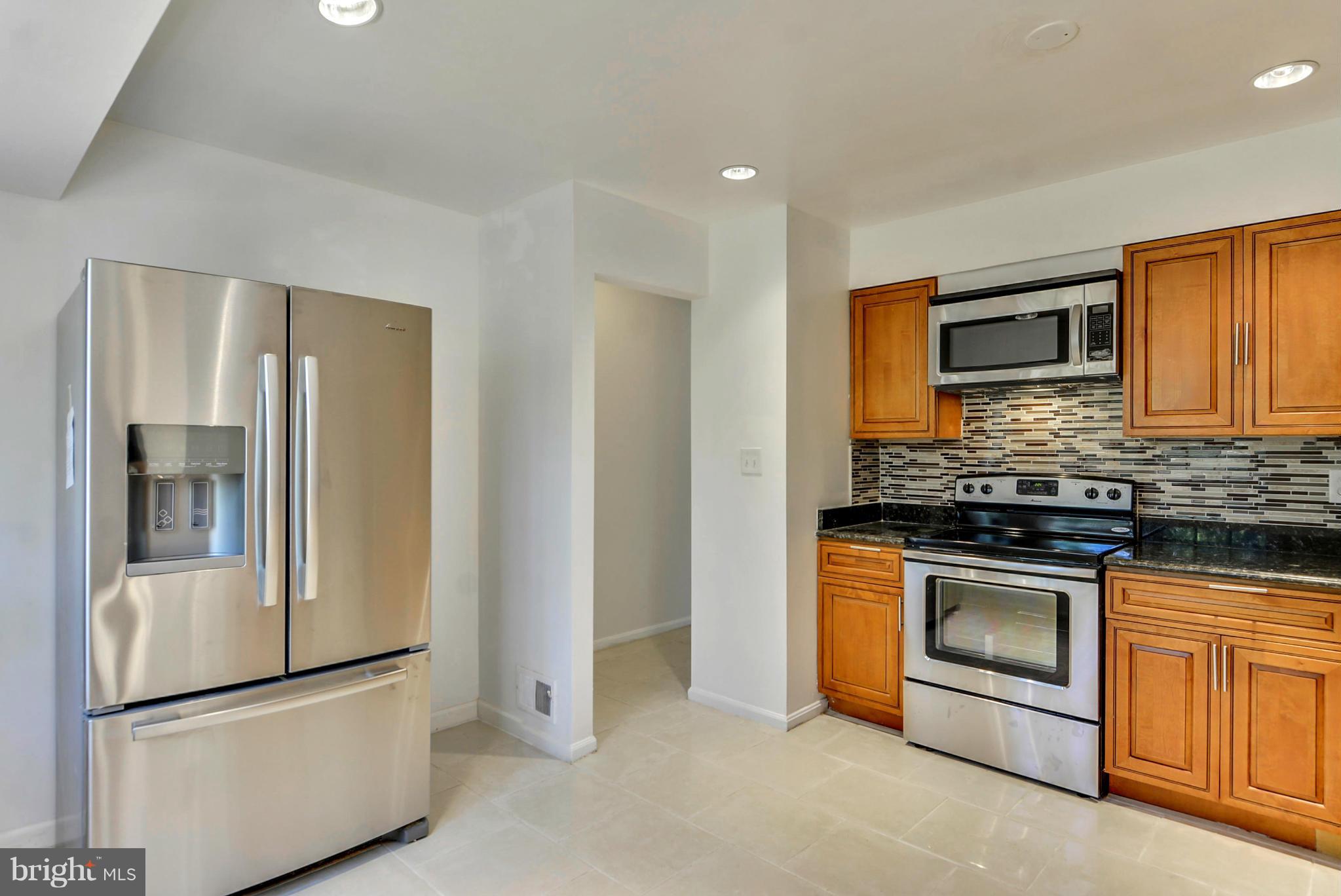 1409 Jackson Road Silver Spring, MD 20904 - Photo 12 of 30 a kitchen with stainless steel appliances granite countertop a refrigerator and a stove top oven