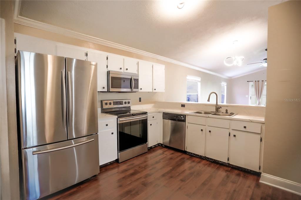 2083 Windward Pass Lakeland, FL 33813 - Photo 2 of 15 a kitchen with stainless steel appliances a refrigerator sink and microwave