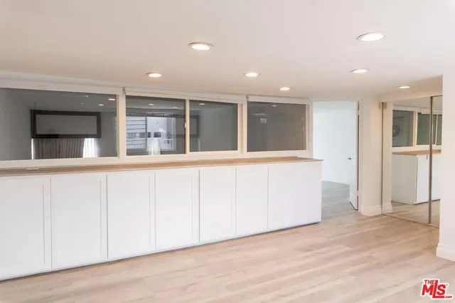 a large white kitchen with a large window