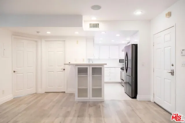 a view of a kitchen with refrigerator and wooden floor