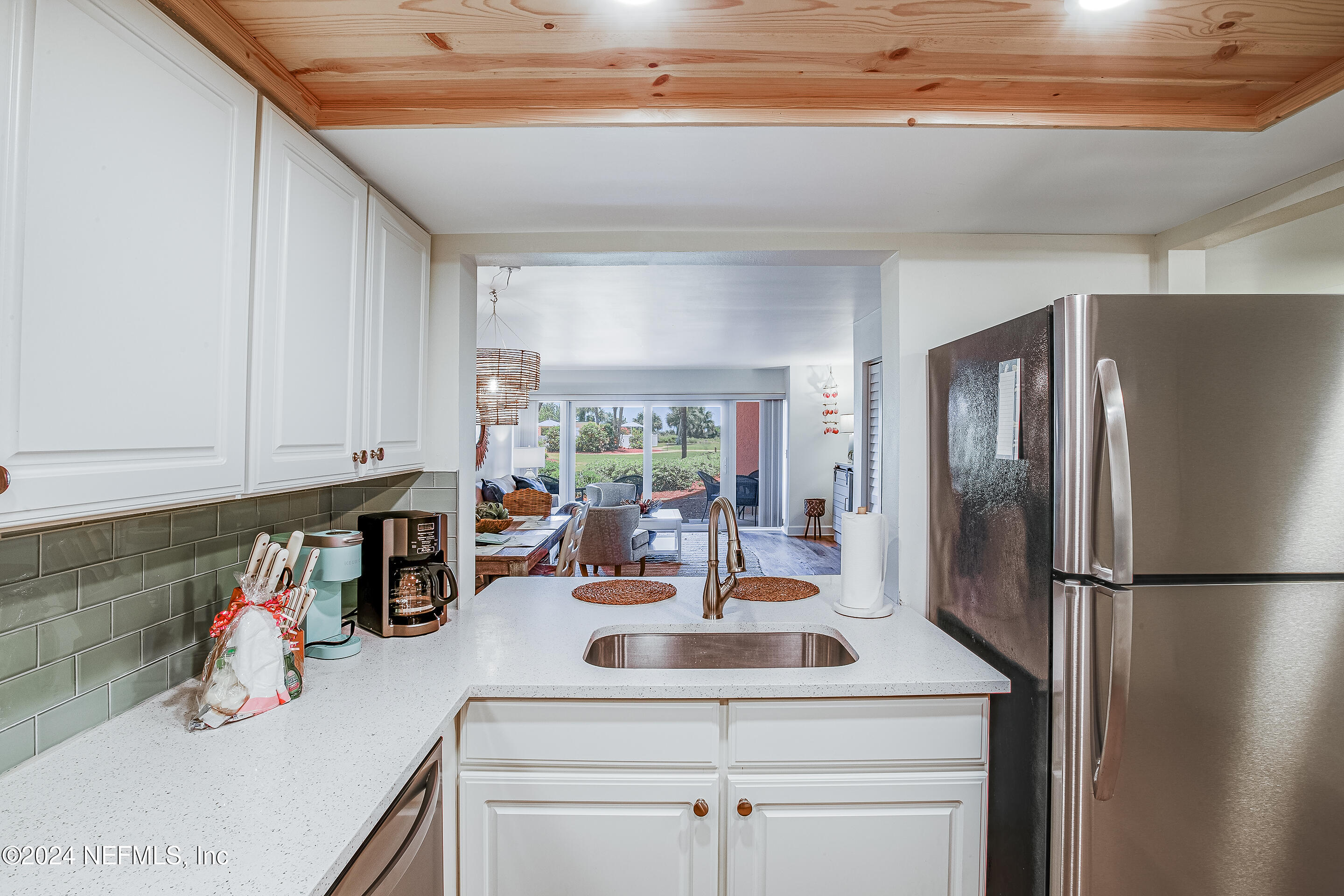 4 Ocean Trace Road, Unit 102 St. Augustine, FL 32080 - Photo 4 of 37 a kitchen with a refrigerator and a sink