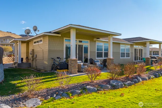 a view of swimming pool with lawn chairs and plants