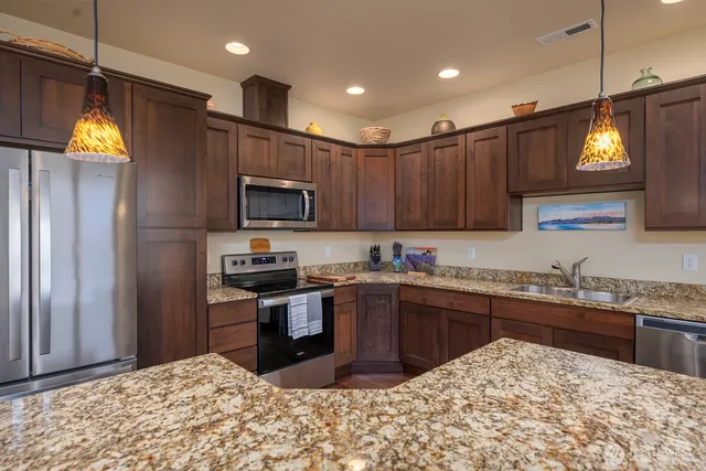 a kitchen with stainless steel appliances granite countertop a sink and a stove