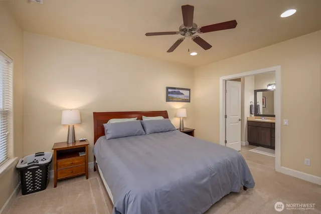a bedroom with a bed a dresser and a chandelier