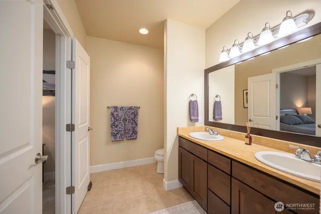 a spacious bathroom with a double vanity sink a large mirror and a shower