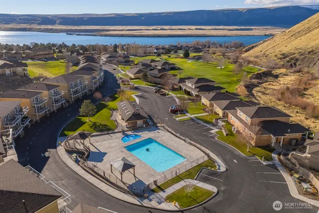 an aerial view of a swimming pool with lawn chairs and potted plants