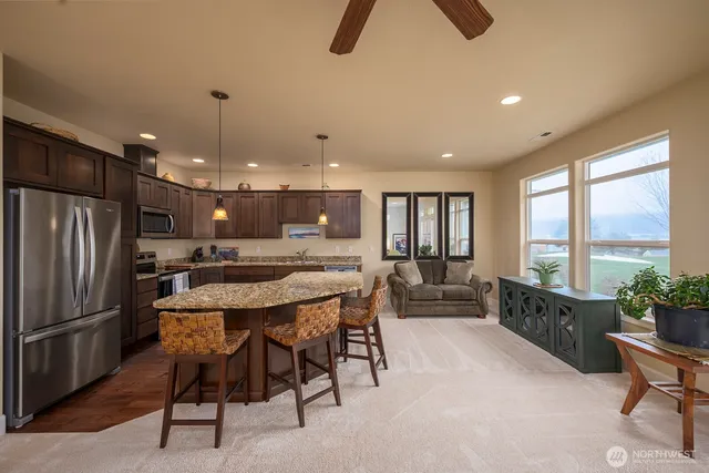 a kitchen with kitchen island a large counter top space appliances and windows