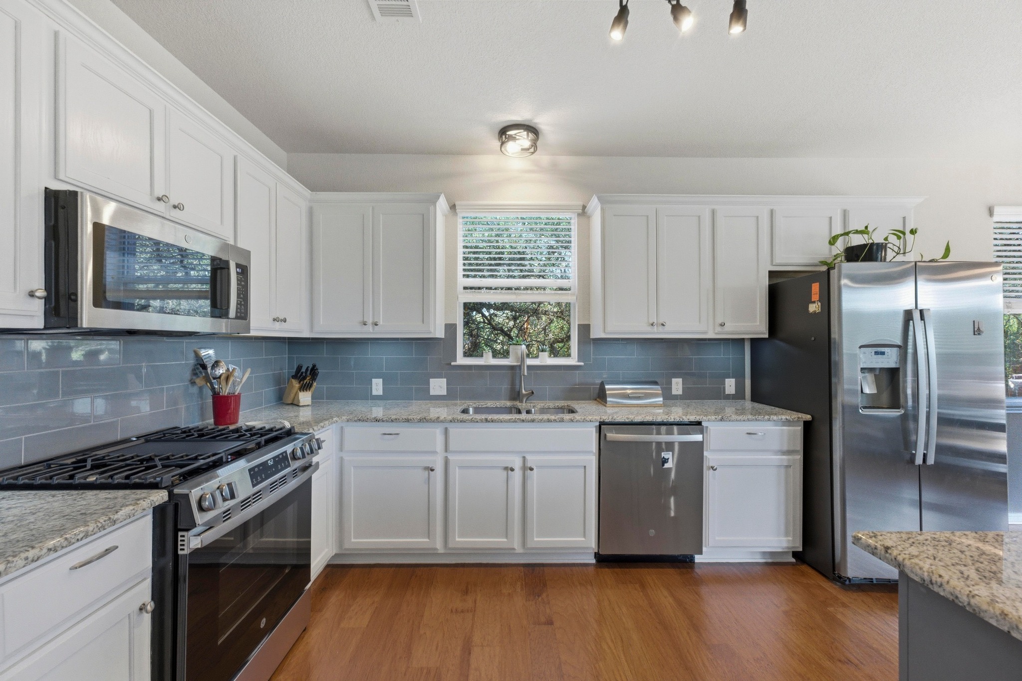 7805 Pitter Pat Lane Austin, TX 78736 - Photo 13 of 40 a kitchen with a stove a sink and a microwave