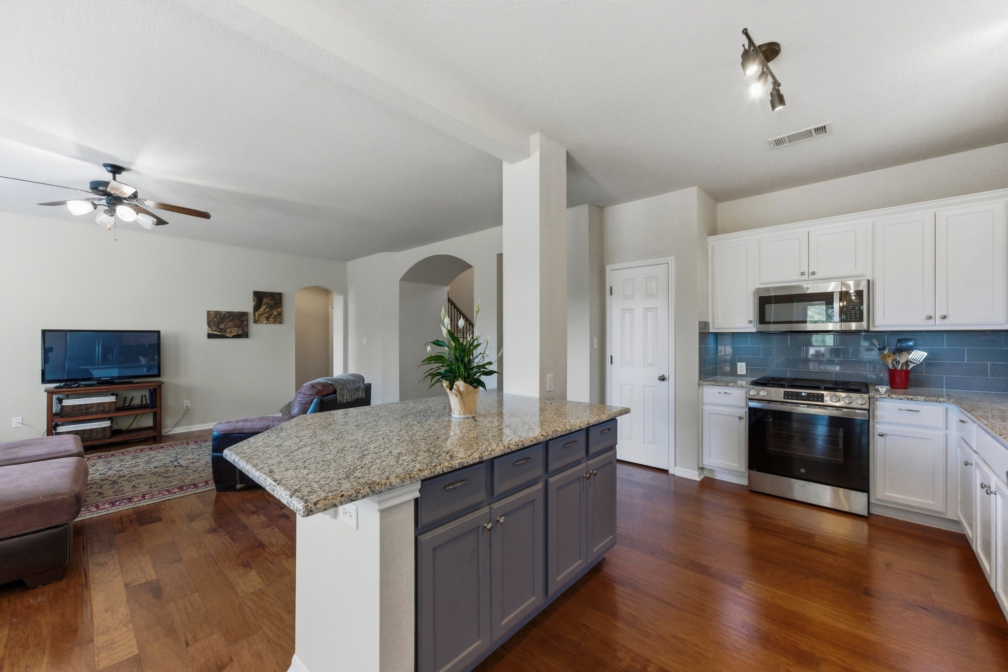 7805 Pitter Pat Lane Austin, TX 78736 - Photo 15 of 40 a kitchen with stainless steel appliances granite countertop a sink dishwasher stove and oven with wooden floor