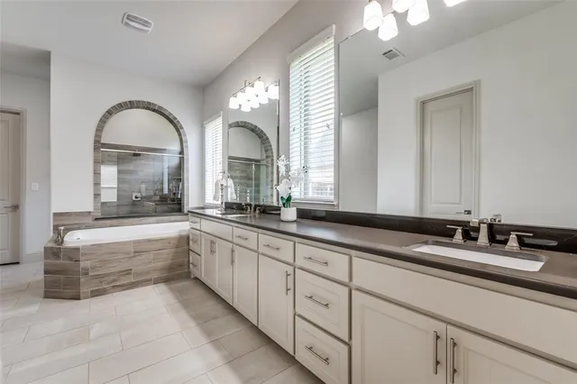 a bathroom with double vanity sinks and a large mirror