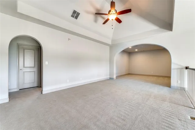 an empty room with a ceiling fan and a window
