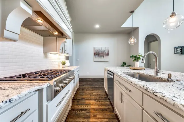 a kitchen with sink stove and cabinets