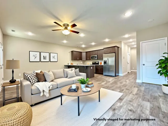 a living room with furniture kitchen view and a chandelier