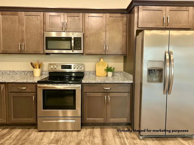 a kitchen with stainless steel appliances granite countertop a refrigerator stove and microwave