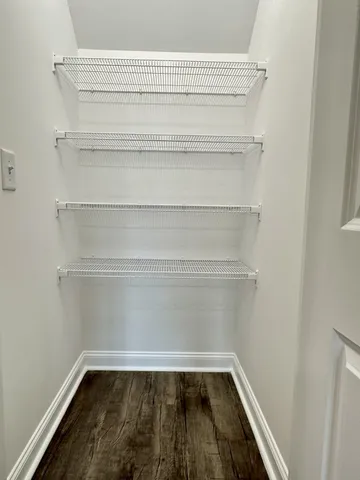 a view of a closet with wooden floor