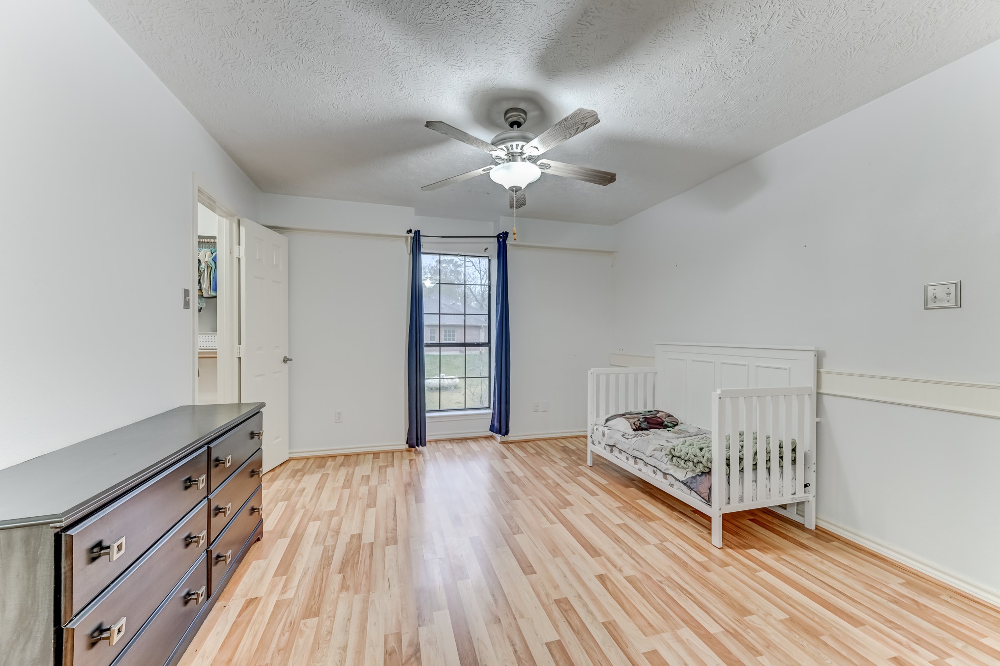 1210 Cherry Creek Road Dayton, TX 77535 - Photo 27 of 50 a bedroom with a bed and a chandelier fan