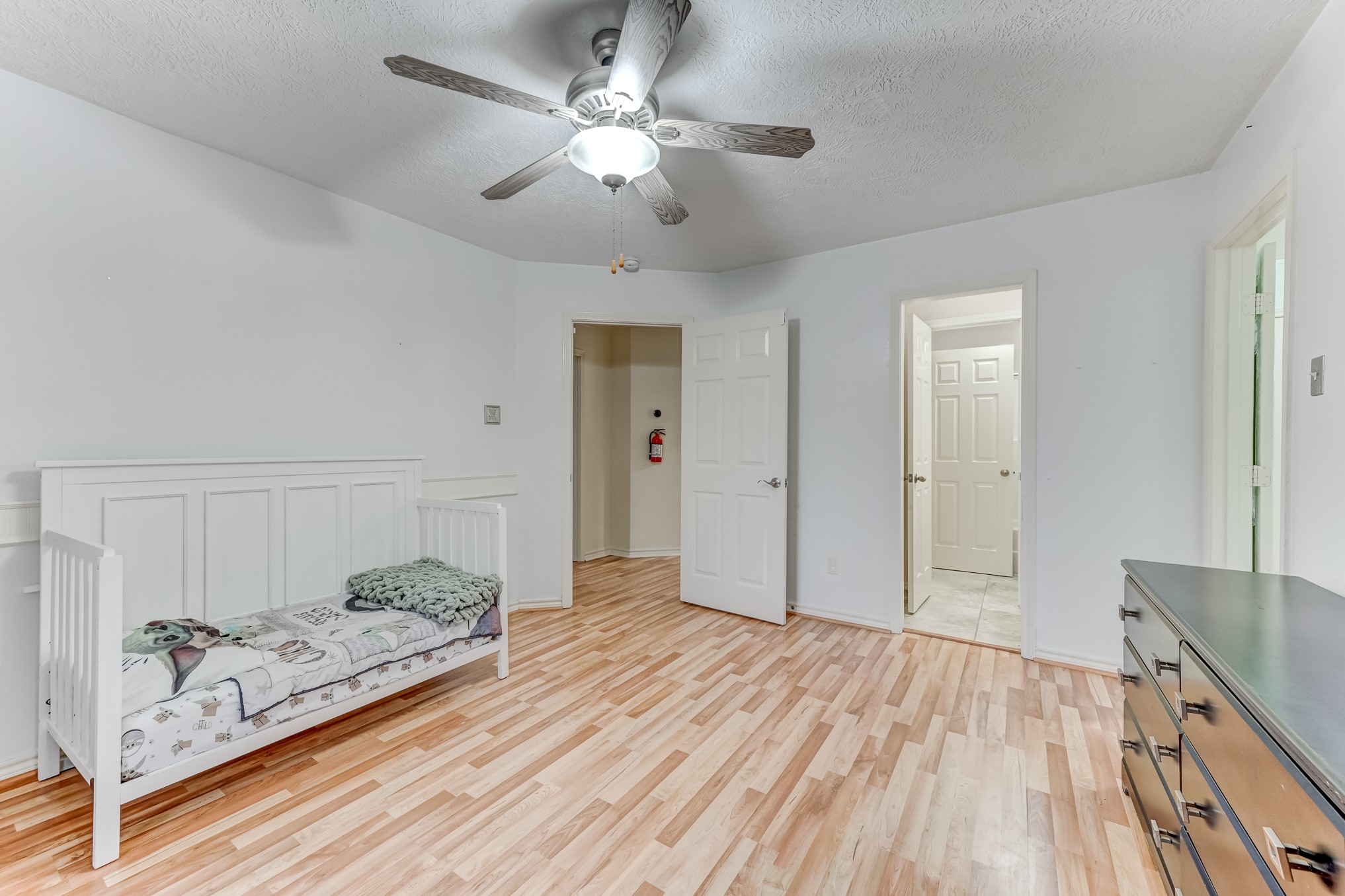 1210 Cherry Creek Road Dayton, TX 77535 - Photo 28 of 50 a spacious bedroom with a bed and a chandelier