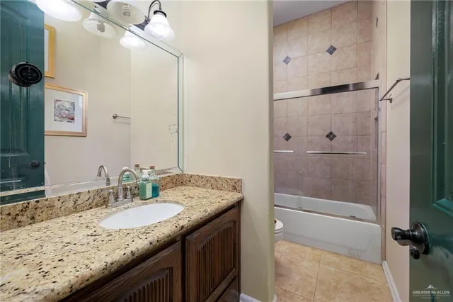 a bathroom with a granite countertop sink a mirror and shower