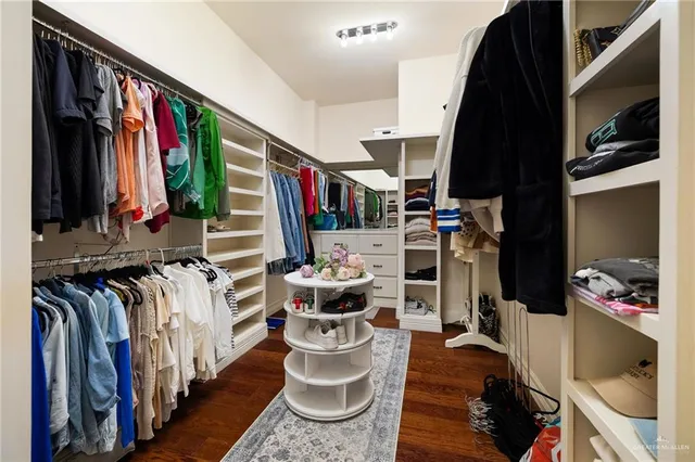 a view of walk in closet with clothes and shoes