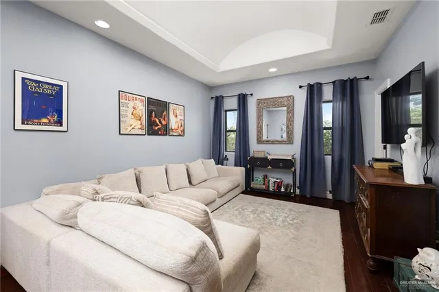 a living room with furniture large mirror and a flat screen tv