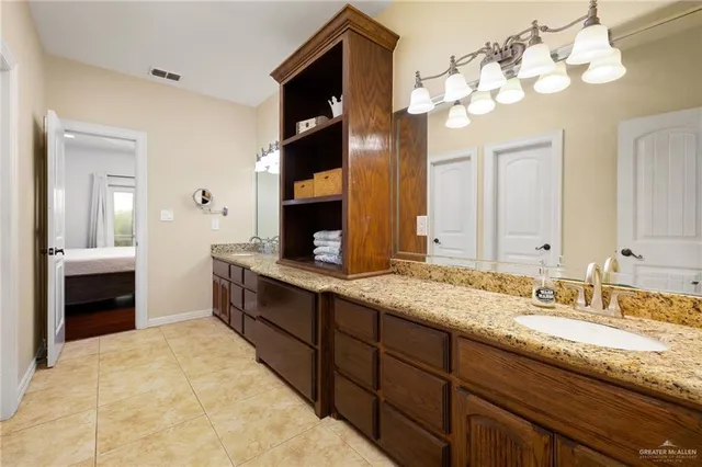 a spacious bathroom with a granite countertop sink and a mirror