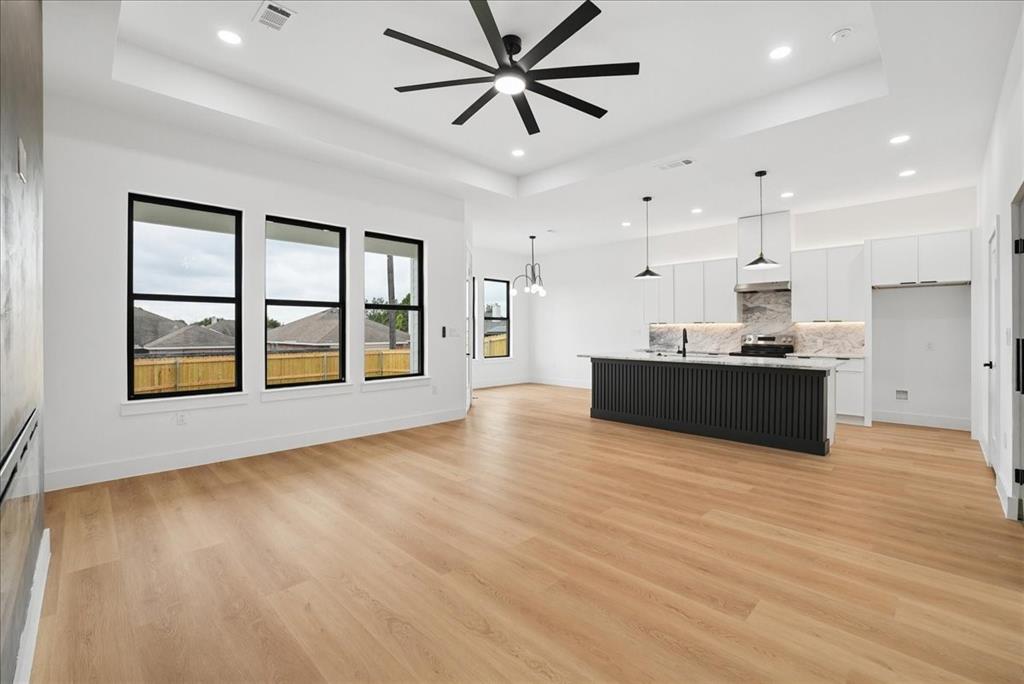 1652 West Wintergreen Road Lancaster, TX 75134 - Photo 6 of 25 Spacious open-concept layout with wood-finish flooring, a contemporary ceiling fan, and recessed lighting