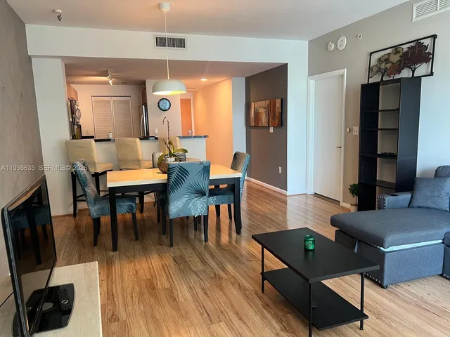 a living room with furniture and a wooden floor