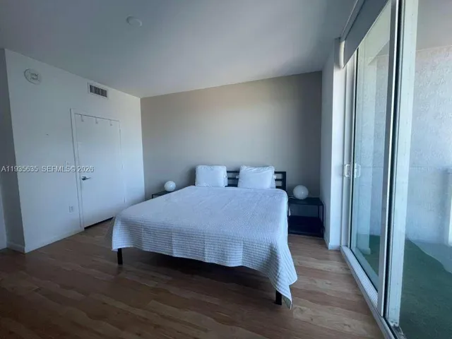 a bedroom with a bed and wooden floor