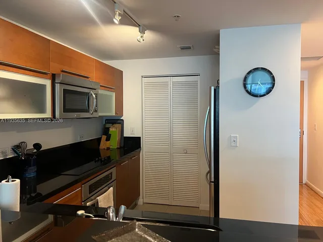 a kitchen with a refrigerator and a stove top oven