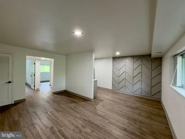 a view of an empty room with wooden floor and closet
