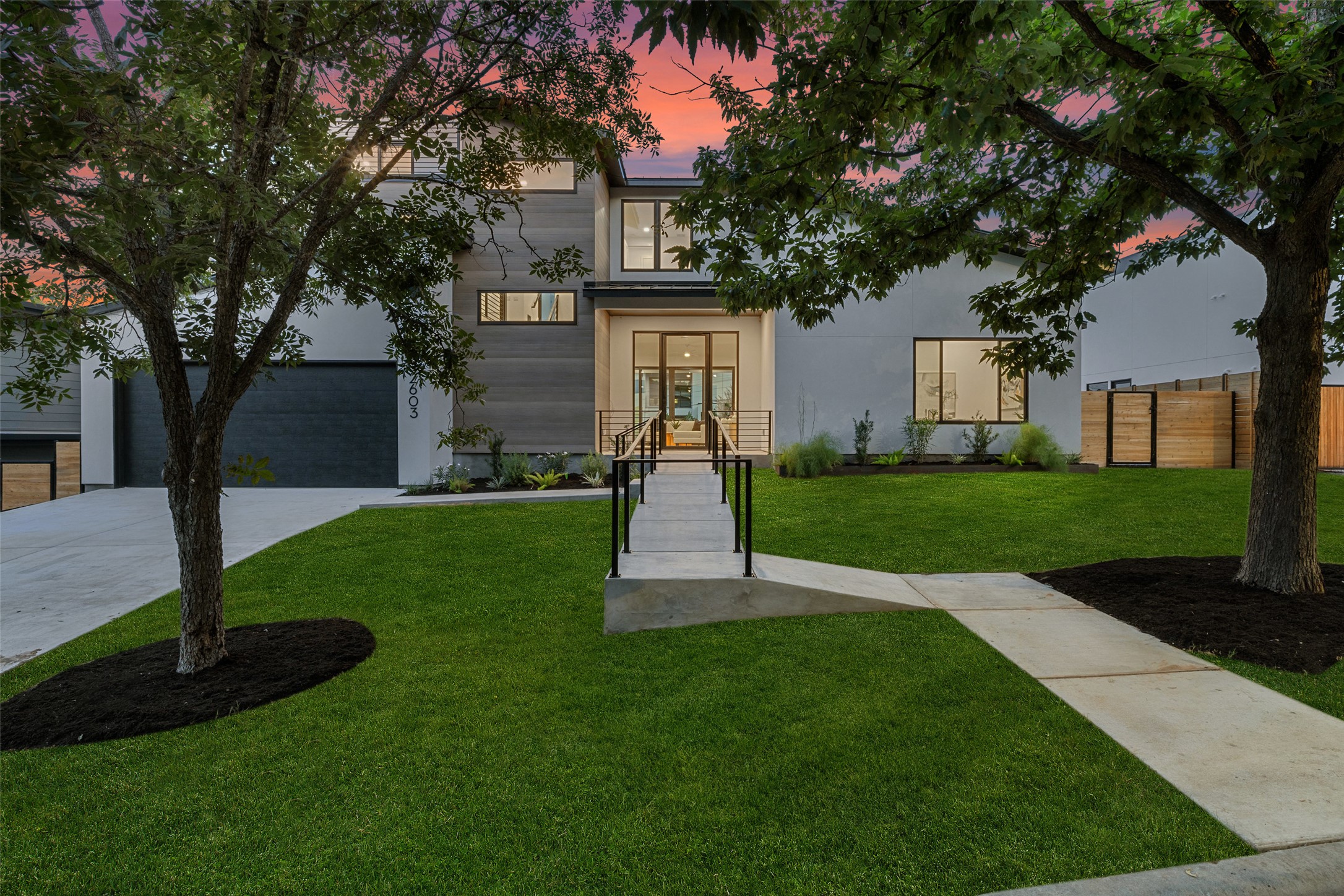 Contemporary house with concrete driveway, a garage, and stucco siding