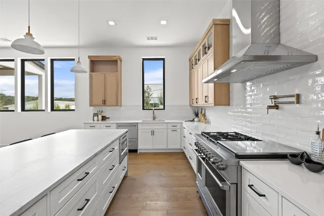 a kitchen with stainless steel appliances a sink stove and cabinets