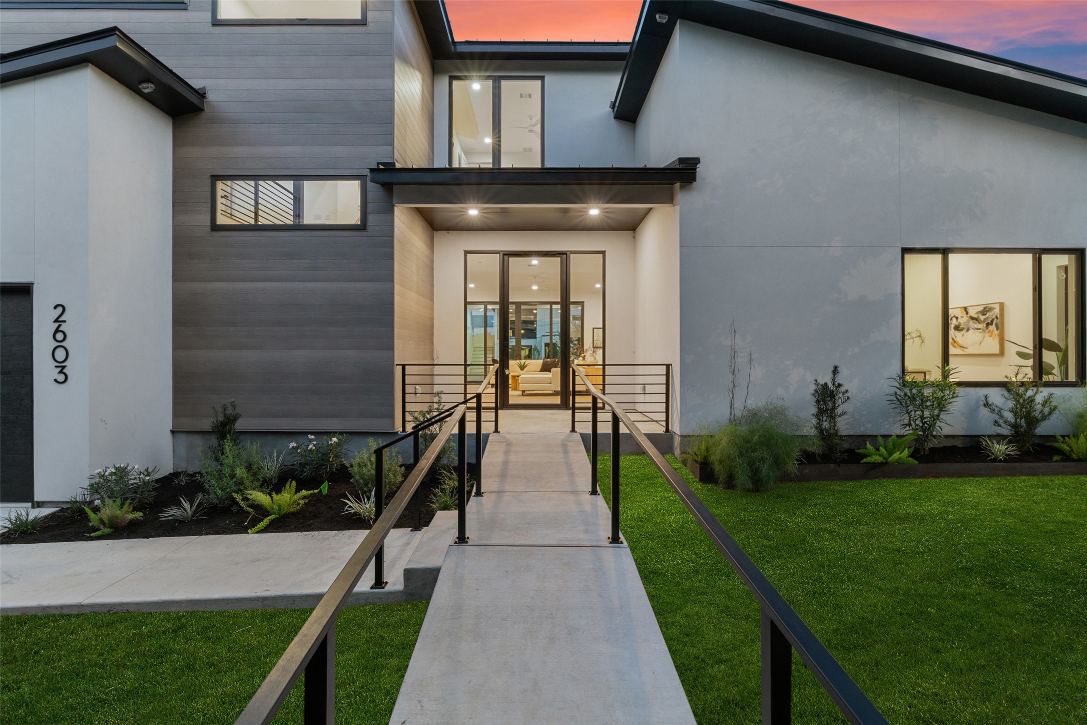 2603 Rockingham Drive Austin, TX 78704 - Photo 3 of 40 Exterior entry at dusk featuring a lawn and stucco siding