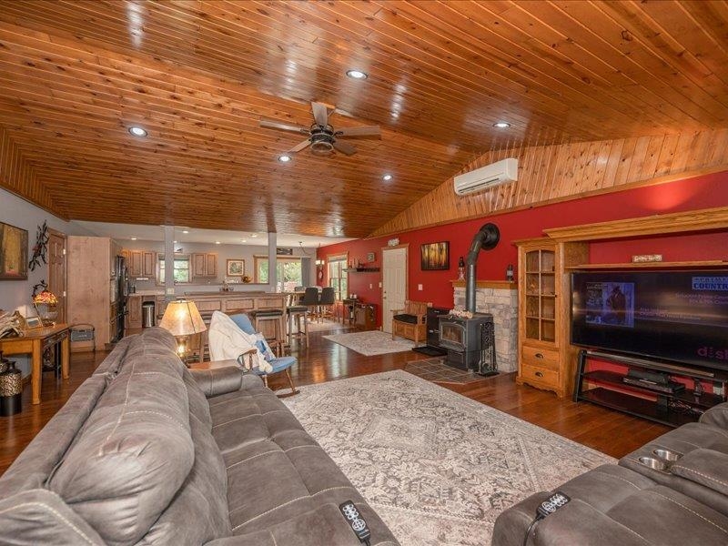 3994 County Rd U South Range, WI 54874 - Photo 13 of 56 Living room featuring a wood stove, dark wood-type flooring, recessed lighting, a ceiling fan, and a wall mounted air conditioner