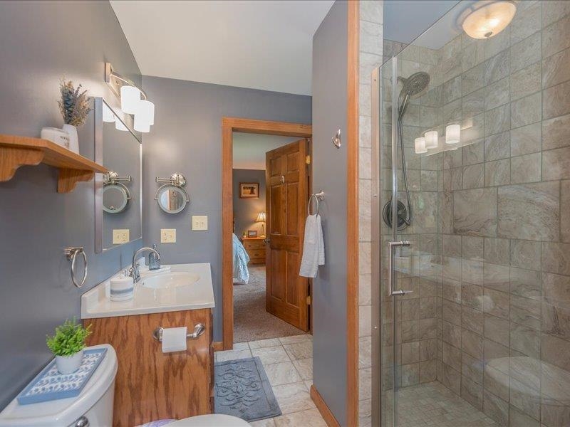 3994 County Rd U South Range, WI 54874 - Photo 22 of 56 Ensuite bathroom featuring a stall shower, vanity, and light tile patterned floors