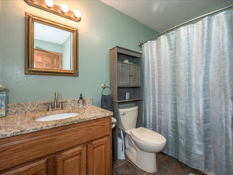 3994 County Rd U South Range, WI 54874 - Photo 28 of 56 Full bathroom with vanity, dark tile patterned flooring, and curtained shower