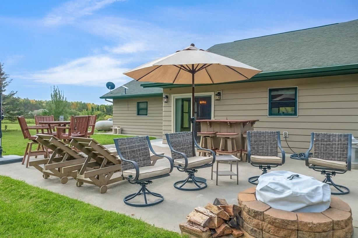 3994 County Rd U South Range, WI 54874 - Photo 7 of 56 Back of house with a shingled roof, a patio area, and a fire pit