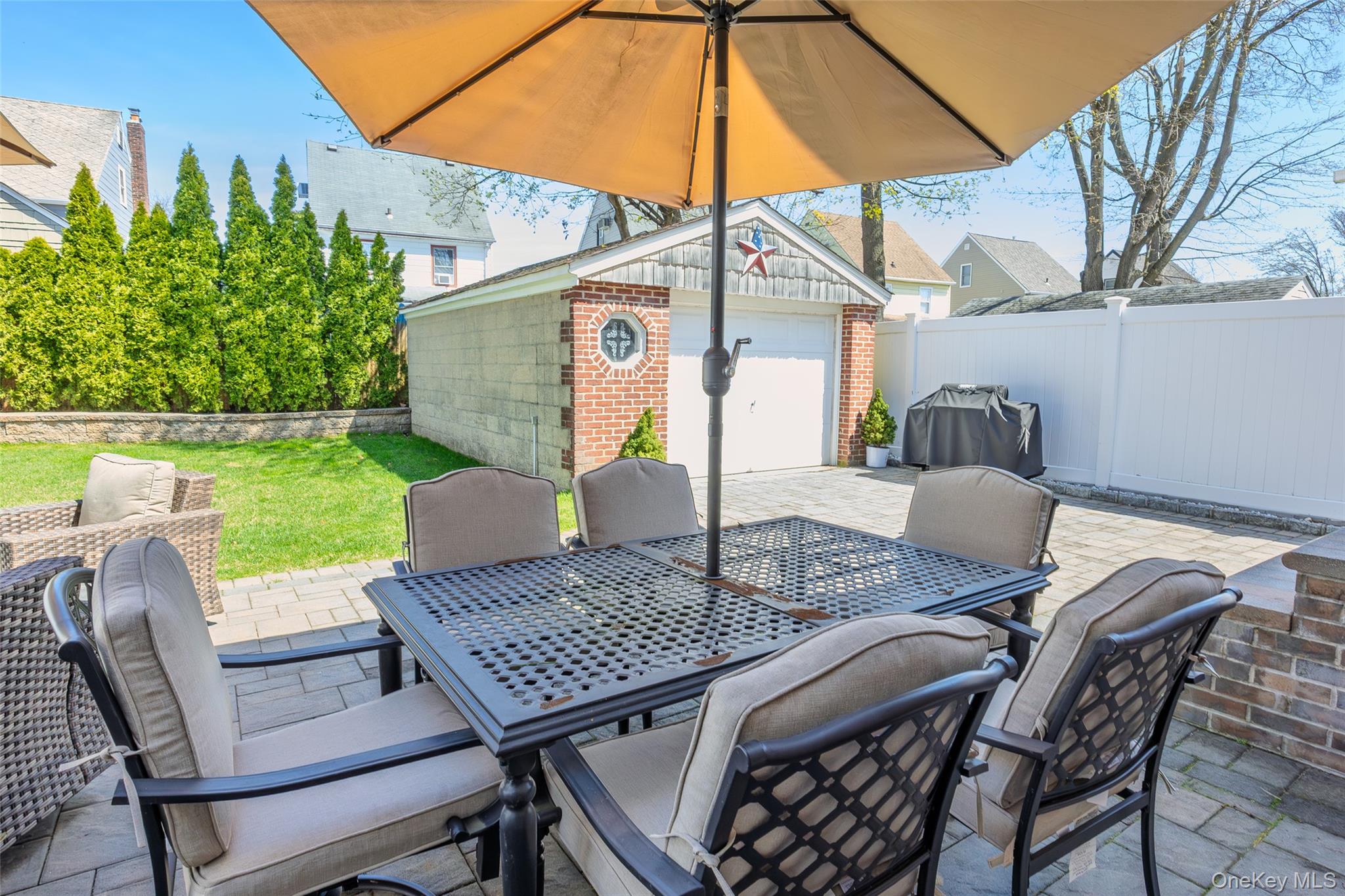 416 Argyle Road Mineola, NY 11501 - Photo 8 of 46 a view of a patio with table and chairs under an umbrella