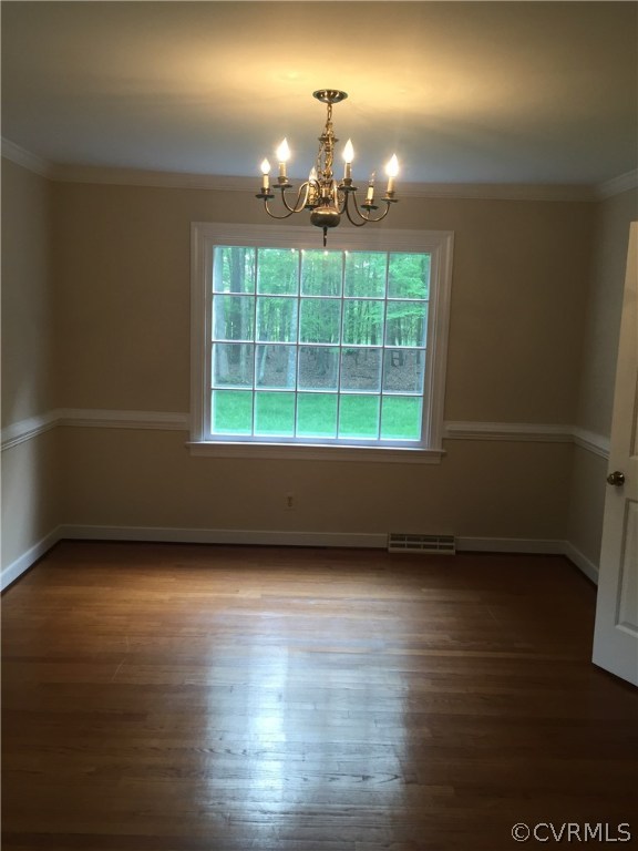 13459 Glendower Road Midlothian, VA 23113 - Photo 10 of 16 an empty room with wooden floor chandelier and fireplace